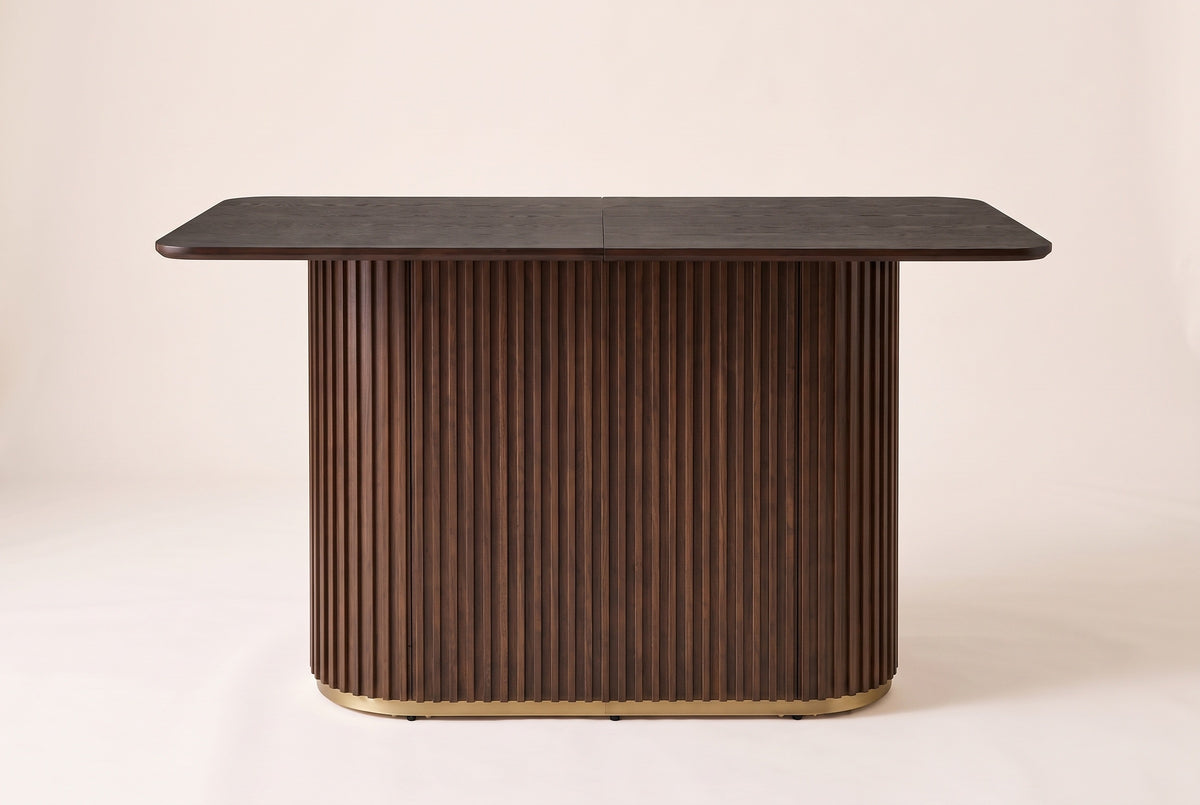 Brugnato counter height table in walnut, front view: a two-piece top with a centre seam on one fluted pedestal with a gold ri