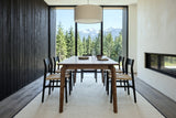 End view of the Calascio dining table in Brown in a Revelstoke mountain house, with a black cedar board wall