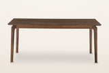 Calascio dining table in Brown, front view on a warm white studio backdrop: a thin top over four splayed legs