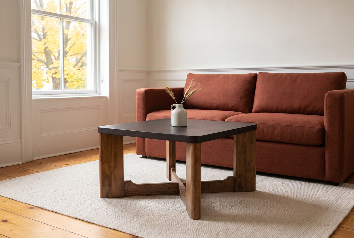 Calcata coffee table in front of a rust wool sofa in a Kingston limestone house, a white jug of dried wheat on top