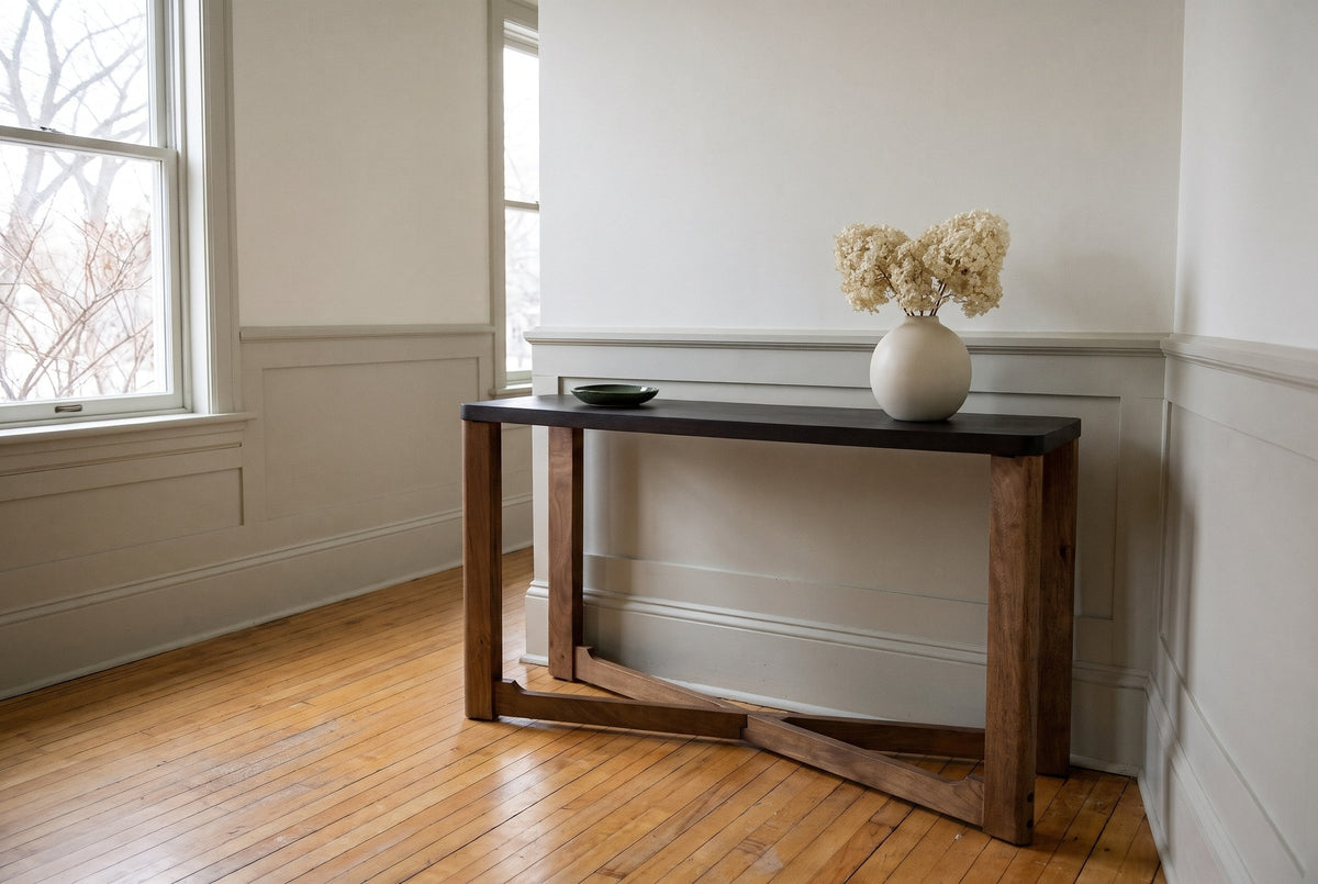 Calcata console table against a putty-grey wainscot in a Wolseley, Winnipeg entry hall, dried hydrangeas in a round cream vase on the mocha top