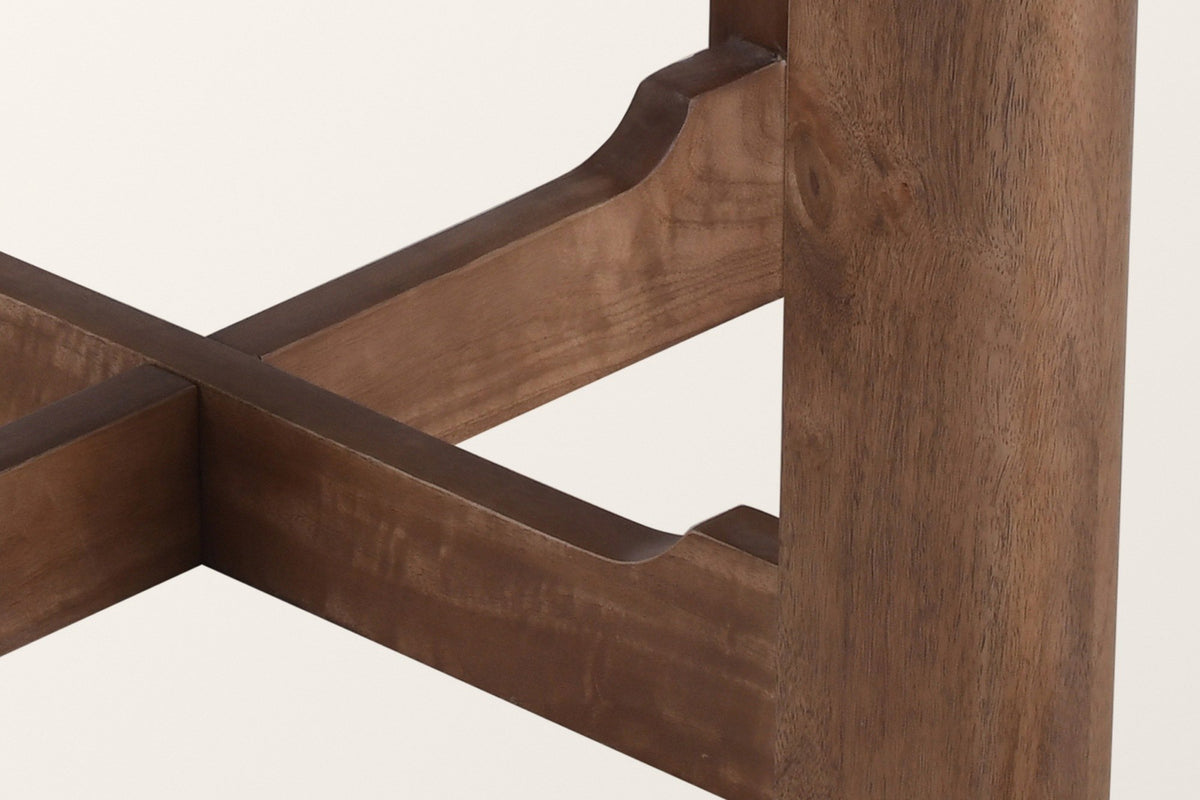 Close-up of the Calcata base: a plank leg, the cove-shaped step of a stretcher arm and the cross joint, walnut finish