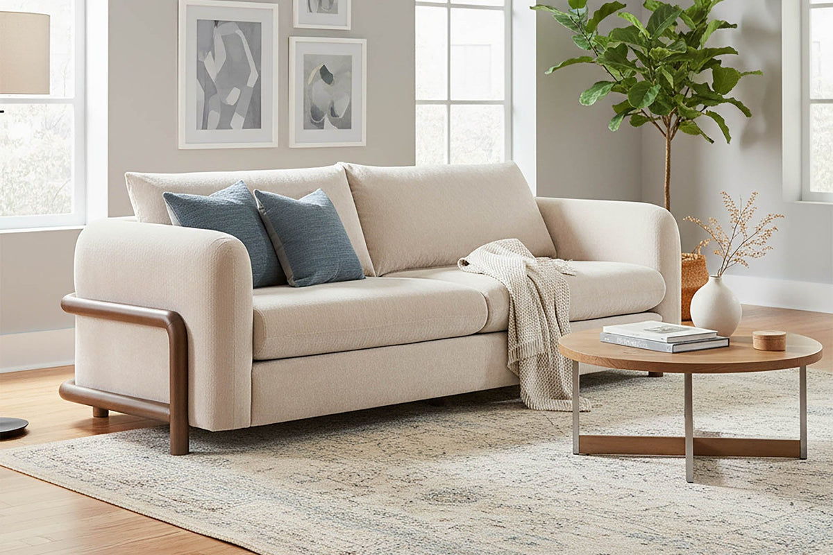 Calista Sand fabric sofa with blue pillows in a bright grey living room