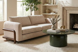 Calista Sand fabric sofa beside a fireplace and built-in shelves