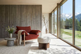 Caltagirone stool in Oatmeal Sand as a footrest by a rust lounge chair in a Klosters chalet