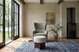 Caltagirone stool in Oatmeal Sand facing the camera before a sage wing chair in a Manotick stone house