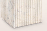 Close-up of the Camerota pedestal corner: narrow marble reeds ending in rounded tips at the floor
