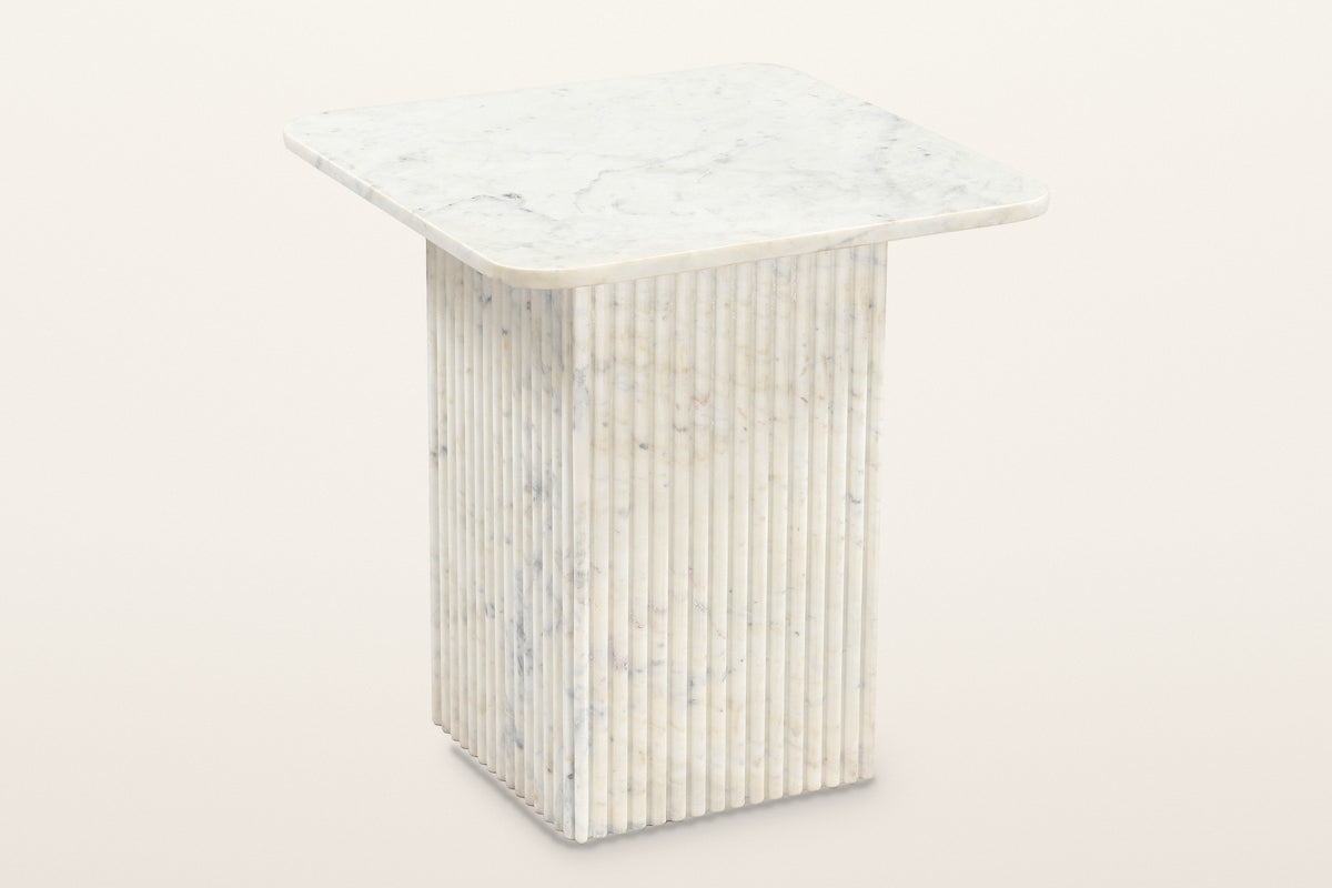 Camerota fluted marble side table in white marble, three-quarter view on a warm white studio backdrop