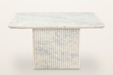 Campiglia coffee table seen from the front: a thin square marble top on one reeded marble pedestal