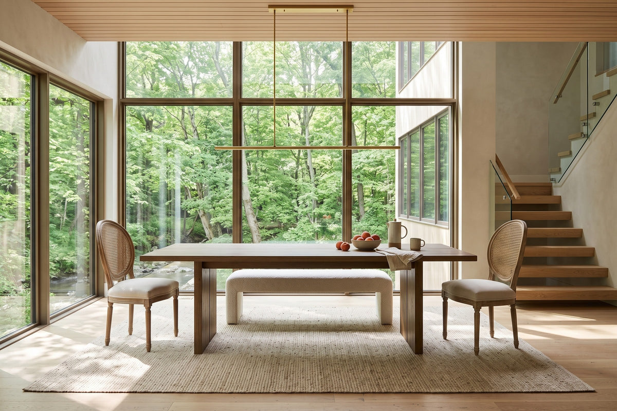 Candelo dining chairs at each end of a smoked-oak table in a Port Hope ravine house