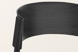 Close-up of the Canelli back in black: the bent band folding around the back post, oak grain under the black stain