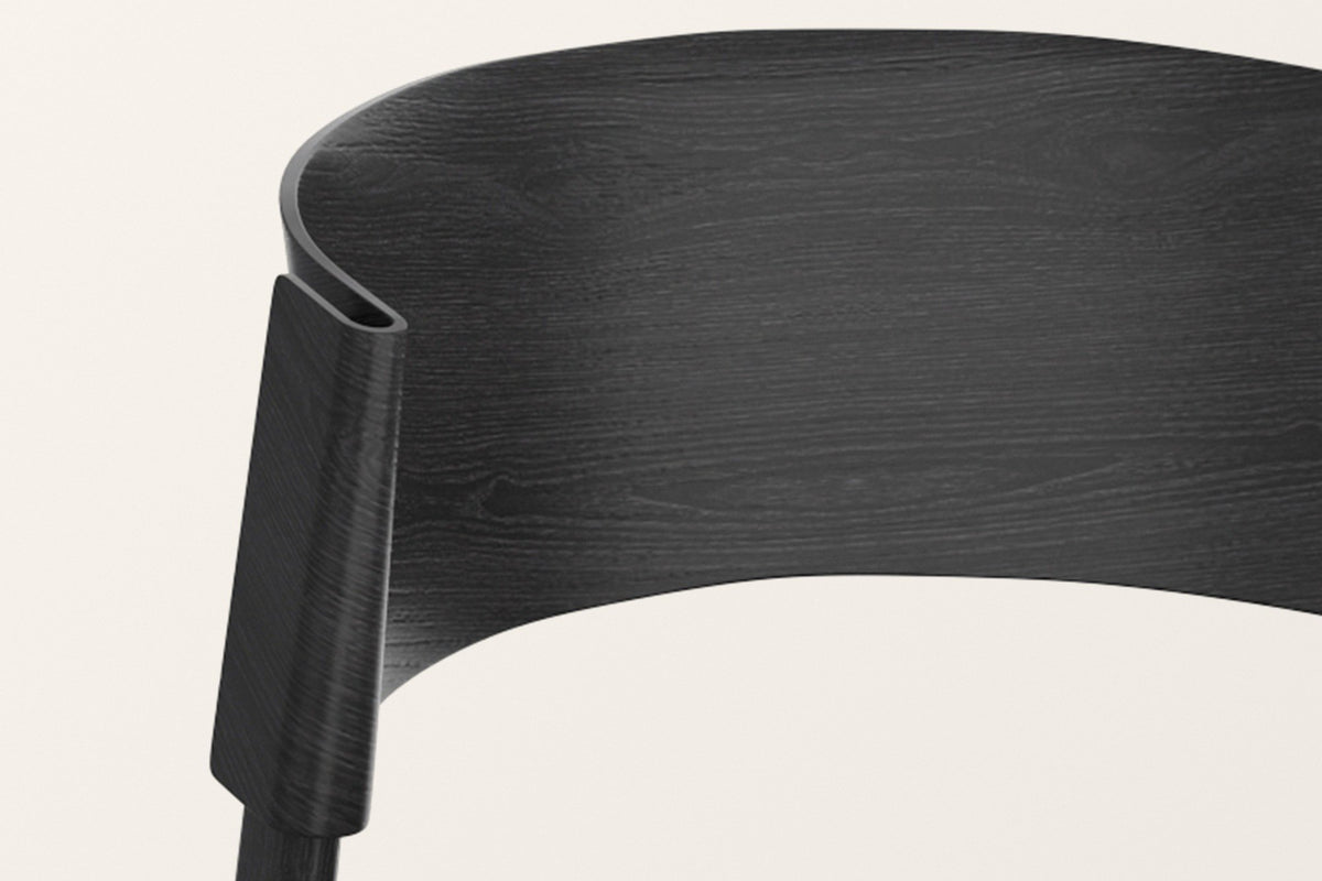 Close-up of the Canelli back in black: the bent band folding around the back post, oak grain under the black stain