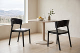 Two Canelli dining chairs in black at a round pale ash table in a bright Calgary dining room