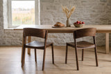 Two Canelli dining chairs in walnut at a long pale oak table in a Prince Edward County farmhouse