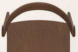 The Canelli chair in walnut seen from above: the half-round back band, its two folded ends and the oak grain of the seat