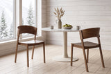Two Canelli dining chairs in walnut at a round marble-top table in a Whistler chalet