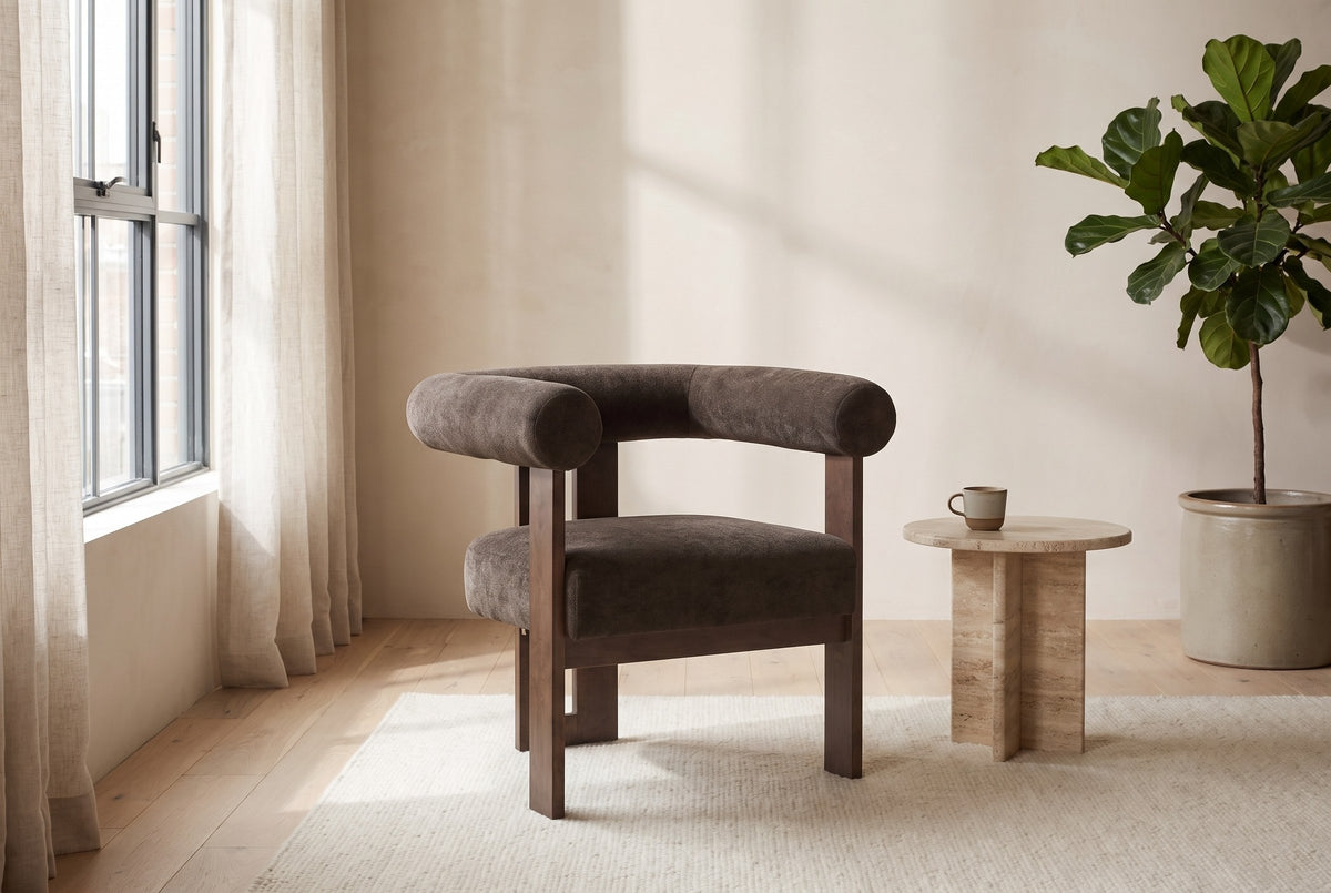 Caorle chair in a bright Montreal loft with linen curtains, a travertine side table and a fiddle-leaf fig