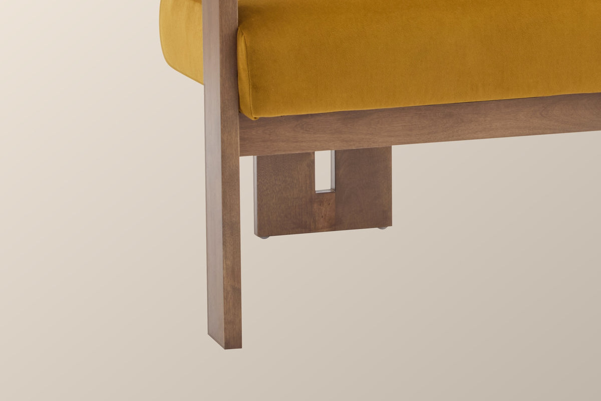 Close-up of a flat solid birch front leg in walnut stain and the slotted rear leg behind it (Mustard Yellow)