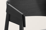Close-up of the Caprarola arm in black: the bent shell folding over the front leg, the oak grain under the black stain