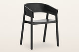 Caprarola dining armchair in black, three-quarter view on a warm white studio backdrop