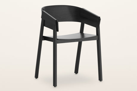 Caprarola dining armchair in black, three-quarter view on a warm white studio backdrop