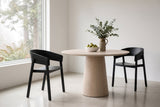 Two Caprarola dining armchairs in black at a round pale oak pedestal table in a West Vancouver house