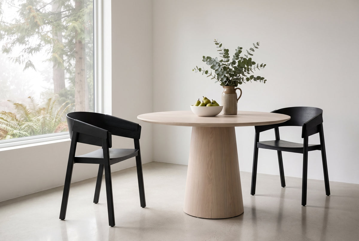 Two Caprarola dining armchairs in black at a round pale oak pedestal table in a West Vancouver house