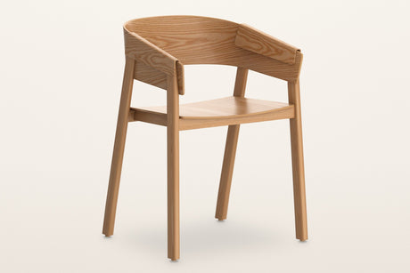 Caprarola dining armchair in natural oak, three-quarter view on a warm white studio backdrop