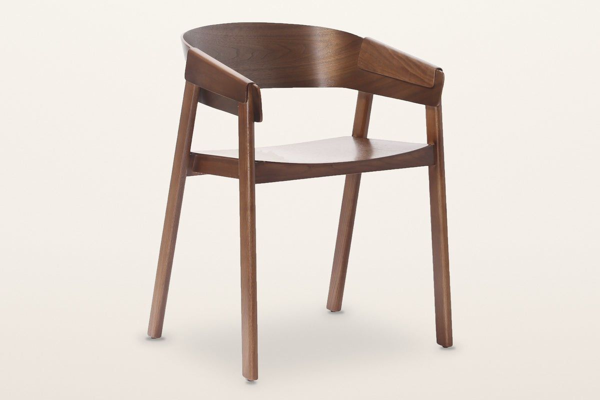 Caprarola dining armchair in walnut, three-quarter view on a warm white studio backdrop