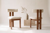 Two Carlo dining chairs, front and back views, beside a travertine block