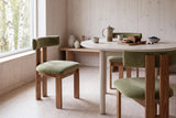 Two olive velvet Carlo dining chairs at a breakfast table in a bright, pale timber apartment in Oslo