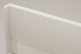 Close-up of the Carrara headboard: the rounded top of a wing, the beige chenille and the one channel line