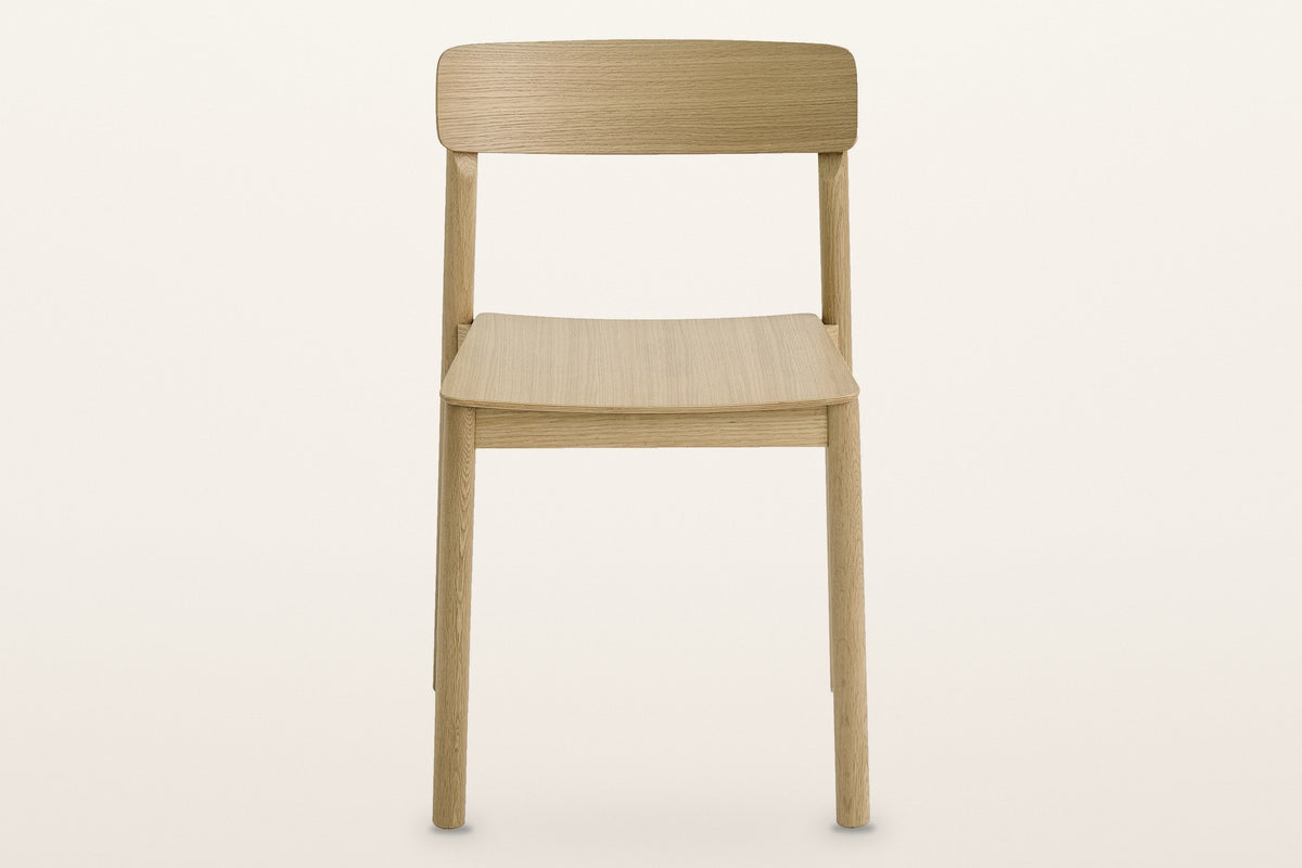 Casole dining chair in natural oak, straight front view: a curved back panel on two round posts over a thin plywood seat