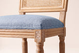 Close-up of the Denim Blue linen-look seat, the reeded rail and the carved rosette on a front corner block