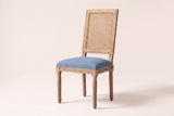 Castelfranco French cane-back dining chair in Denim Blue, three-quarter view on a warm off-white backdrop