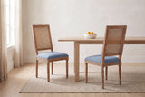 A pair of Castelfranco dining chairs in Denim Blue in a bright Vancouver dining nook with a pale oak table and a bowl of lemo