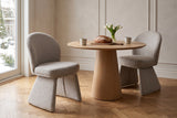Two Castellabate dining chairs in beige at a round light-oak pedestal table in an Ottawa townhouse with panelled plaster wall