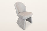 Castellabate sculpted boucle dining chair in beige, three-quarter view on a warm white studio backdrop