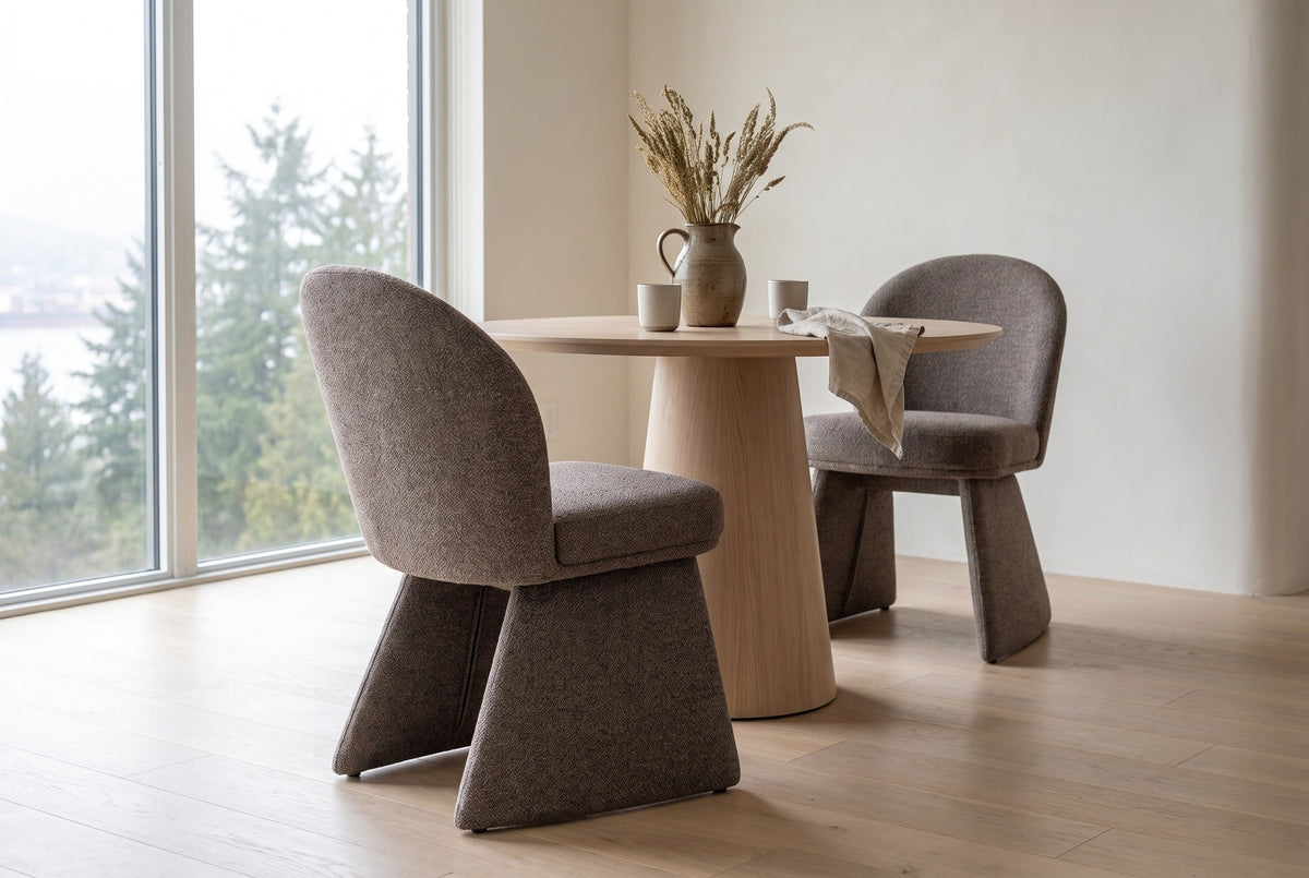 Two Castellabate dining chairs in brown at a round pale-oak pedestal table in a Vancouver condo