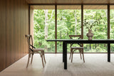 A Castelmola dining chair in Sundried in side profile at a black ash table in a Hockley Valley house