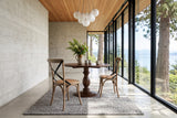 Two Castelmola dining chairs in Sundried at a round walnut pedestal table in a Port Renfrew house on Vancouver Island