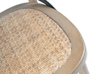 Close-up of the Castelmola seat in Sundried: herringbone-woven rattan set in a rounded elm rim, with an iron strap above
