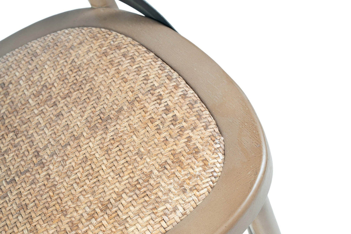 Close-up of the Castelmola seat in Sundried: herringbone-woven rattan set in a rounded elm rim, with an iron strap above