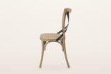 Castelmola dining chair in Sundried, side view on a warm white studio backdrop: the back post curves back above the seat