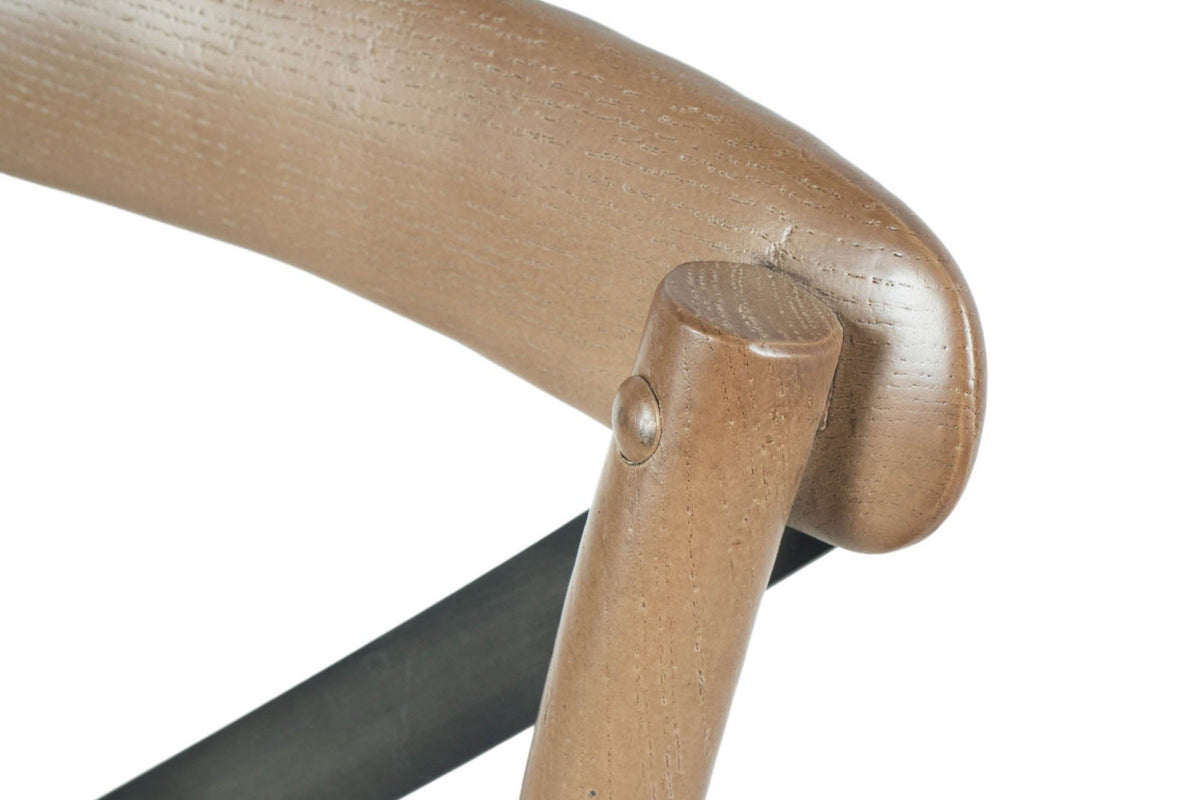 Close-up of the Castelmola top rail in Sundried: the rounded post top, the curved rail and a bolted iron strap