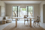 Two Castelmola dining chairs in Sundried at an oval pale-oak table in a Uzes courtyard house, with limewashed walls