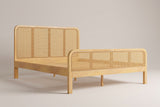 Certaldo cane bed in natural solid wood, three-quarter view on a warm studio backdrop