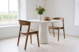 Two Certosa dining chairs in walnut at a round white limestone pedestal table in a Prince Edward County farmhouse
