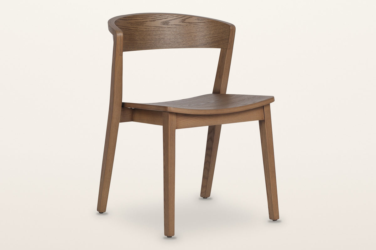 Certosa dining chair in walnut, three-quarter view on a warm white studio backdrop