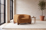 Cervia lounge chair in a bright Montreal loft with whitewashed brick, an ivory rug and an olive tree (Caramel)